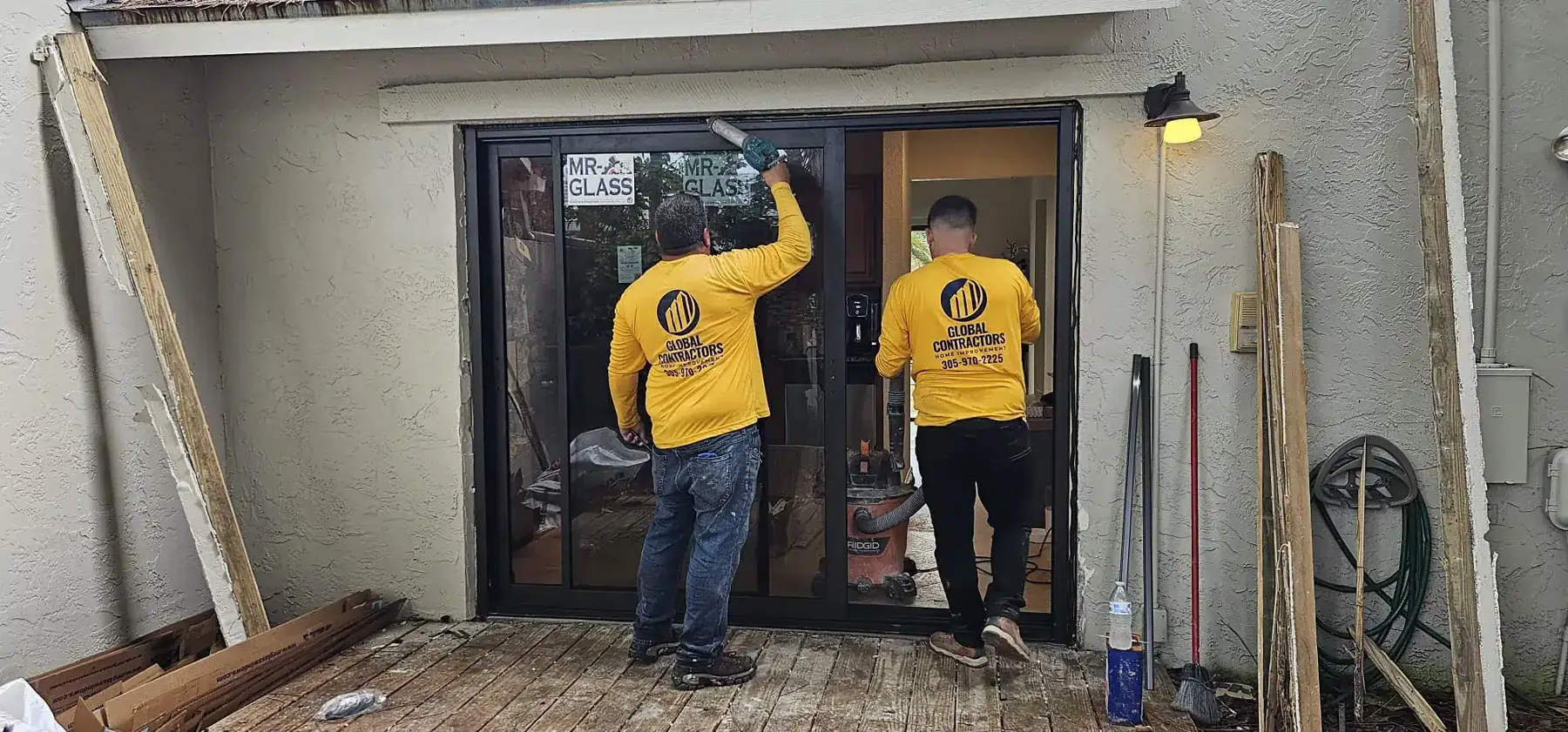 Dos instaladores colocando una puerta corrediza de impacto nueva