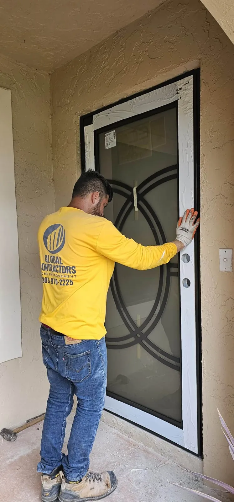 Un instalador de Global Contractors colocando una puerta de entrada