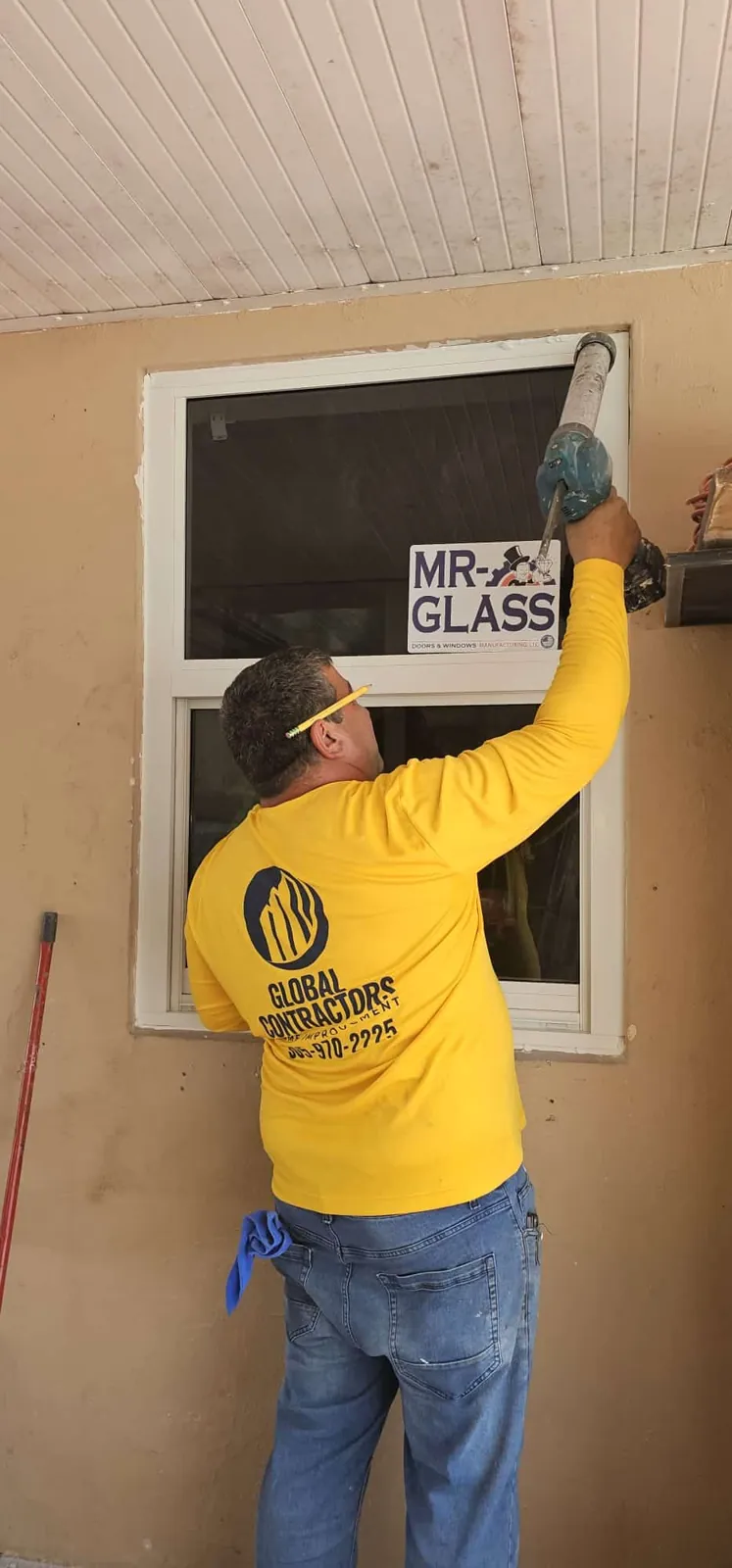 Instalador de Global Contractors colocando una ventana de impacto Mr. Glass