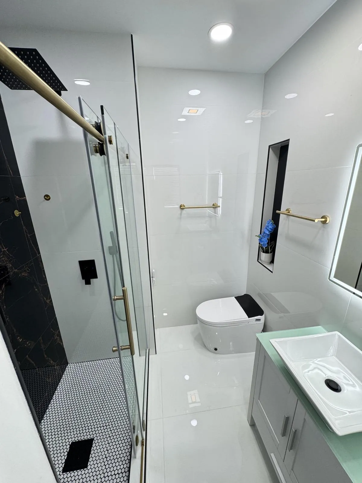 Finished bathroom with a black-and-white tiled shower and a floating vanity