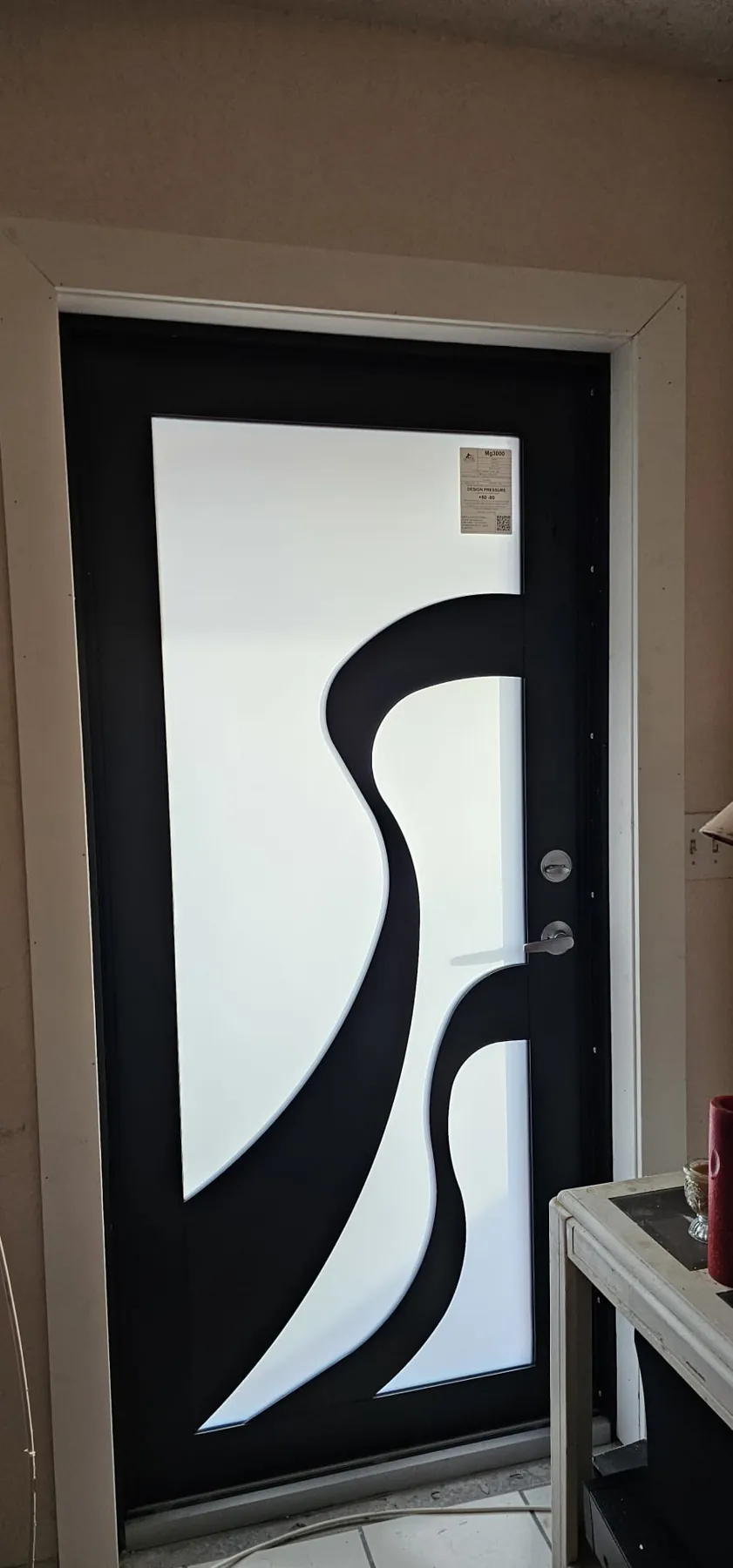 Puerta de entrada de impacto negra con diseño decorativo de ondas