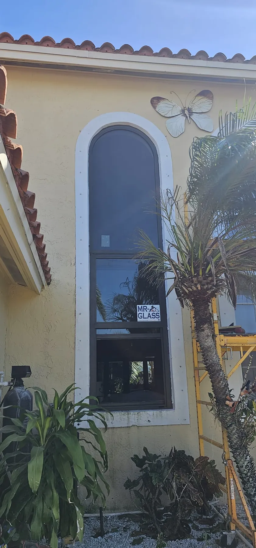 Ventana de impacto alta en arco en una casa de estuco