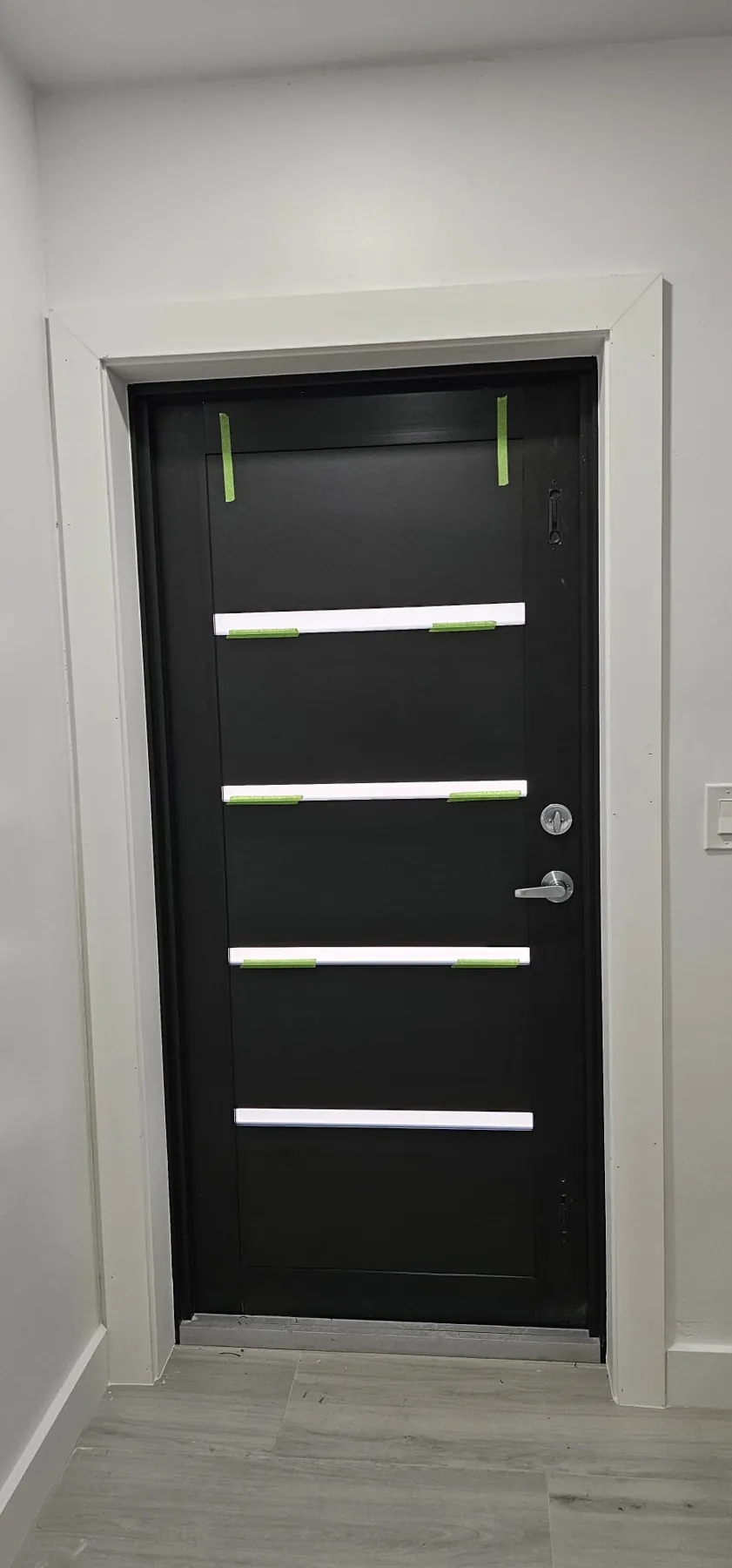 Puerta de entrada de impacto moderna negra con franjas de vidrio horizontales