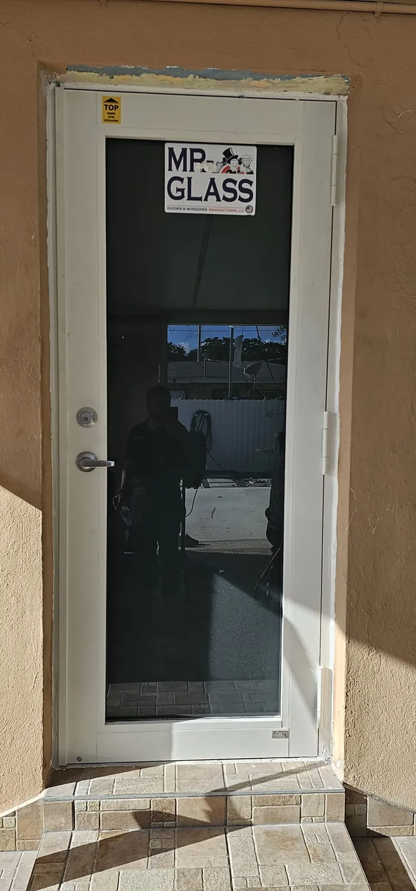Puerta de entrada de impacto blanca con vidrio claro y etiqueta de Mr. Glass