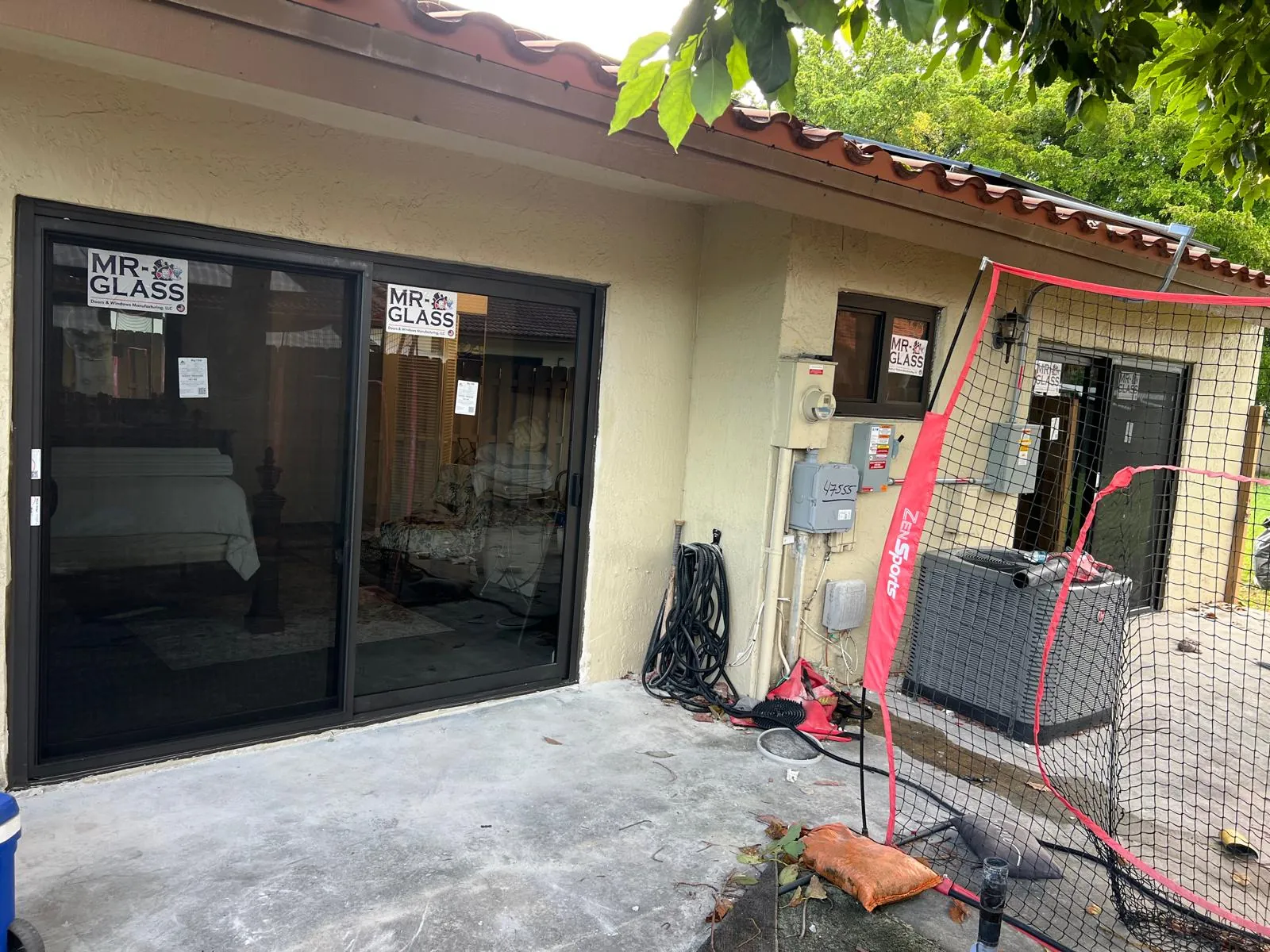 Puertas corredizas de vidrio de impacto negras en un patio