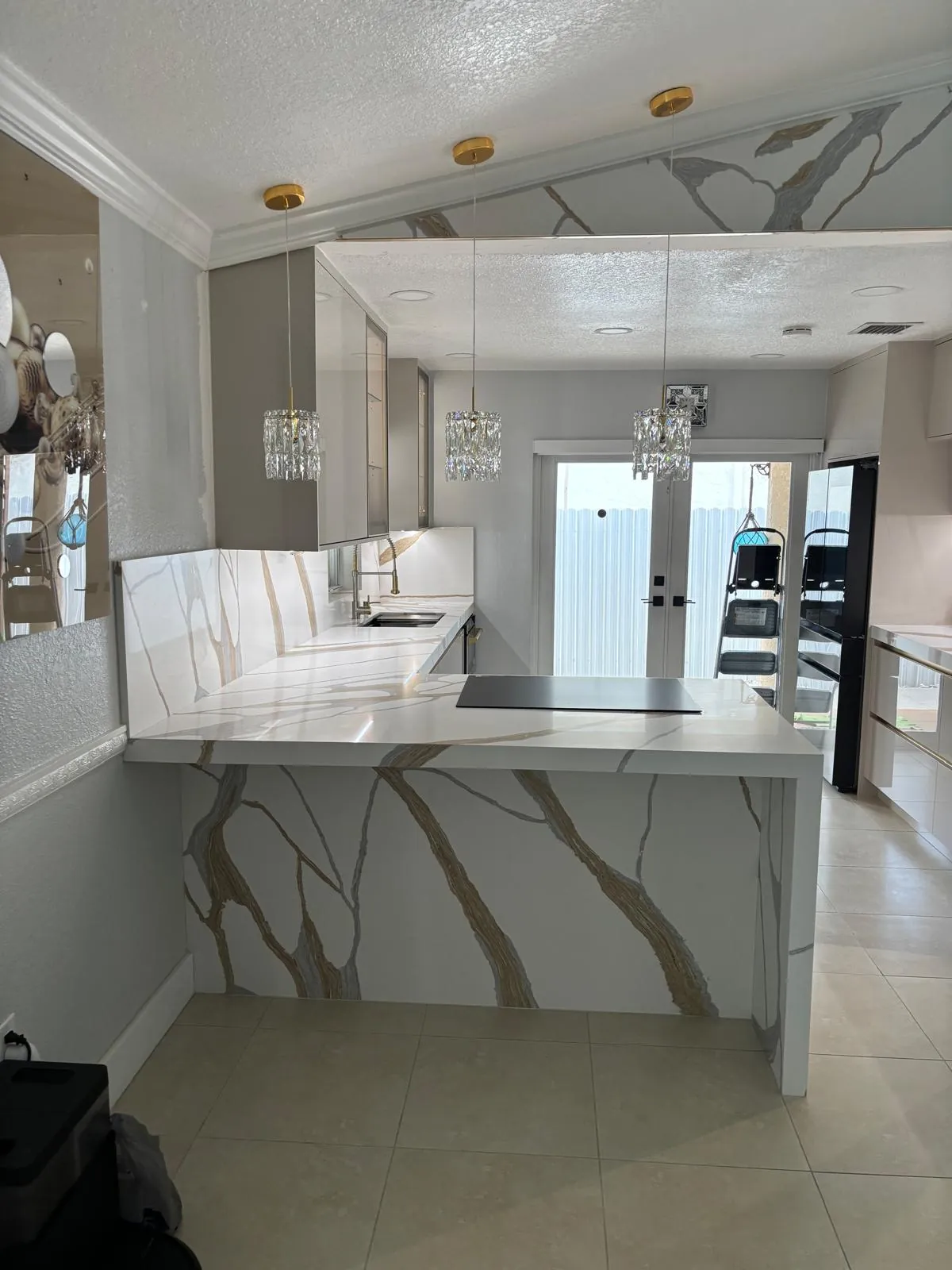 Finished kitchen with a quartz waterfall peninsula