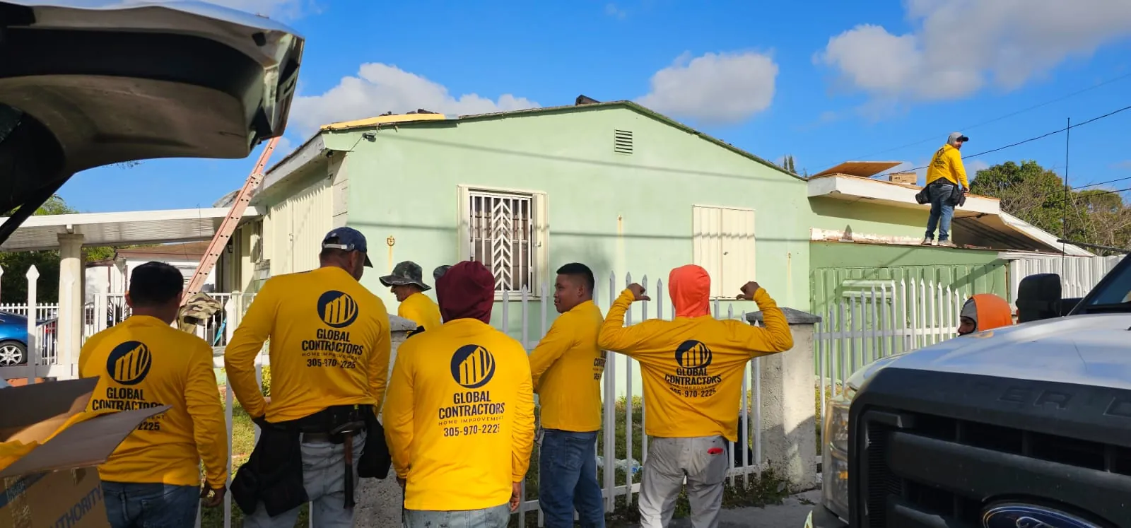 Cuadrilla de Global Contractors frente a una casa antes de un trabajo de techo
