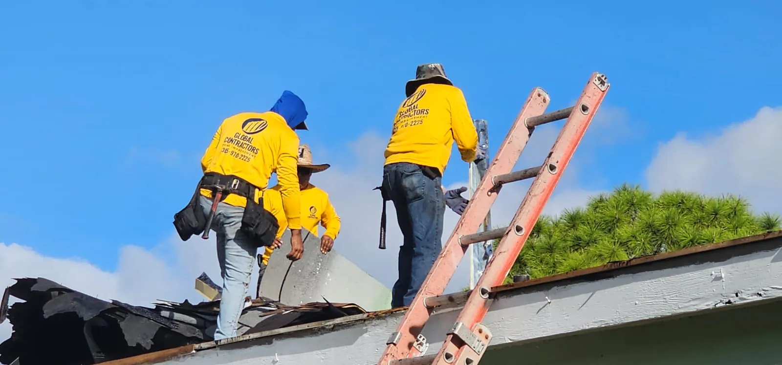 Cuadrilla de Global Contractors quitando el techo viejo, con una escalera en el borde