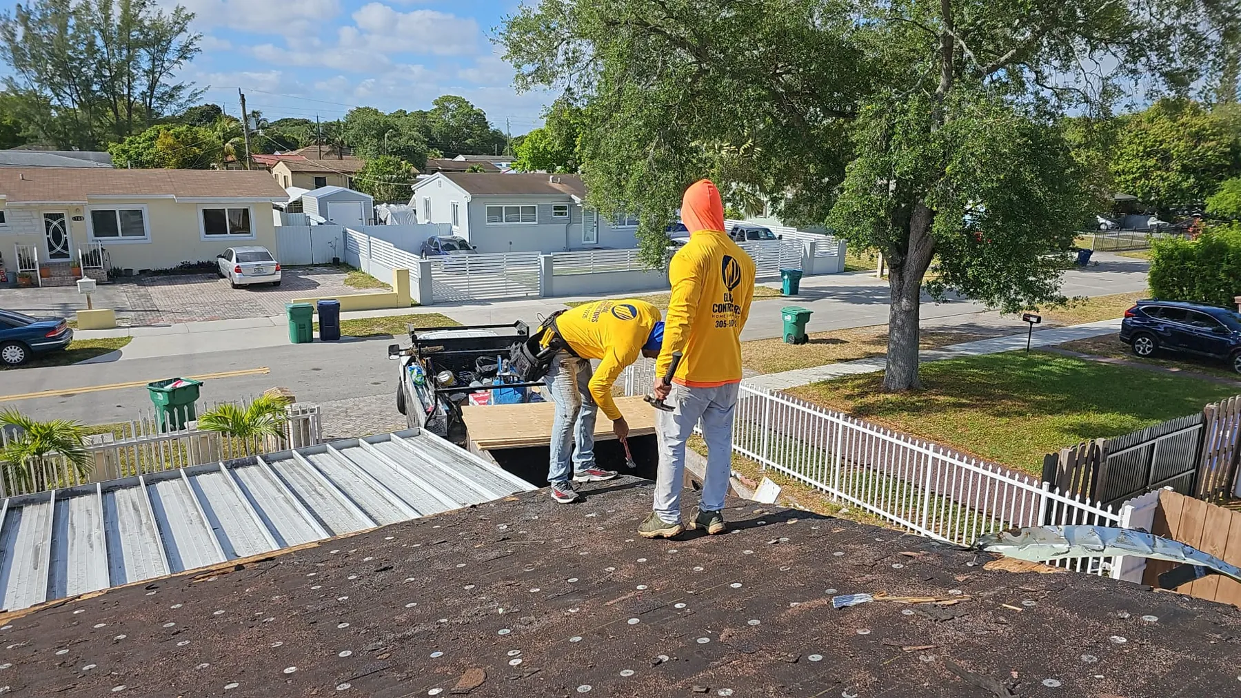 Cuadrilla de Global Contractors trabajando sobre la base de un techo