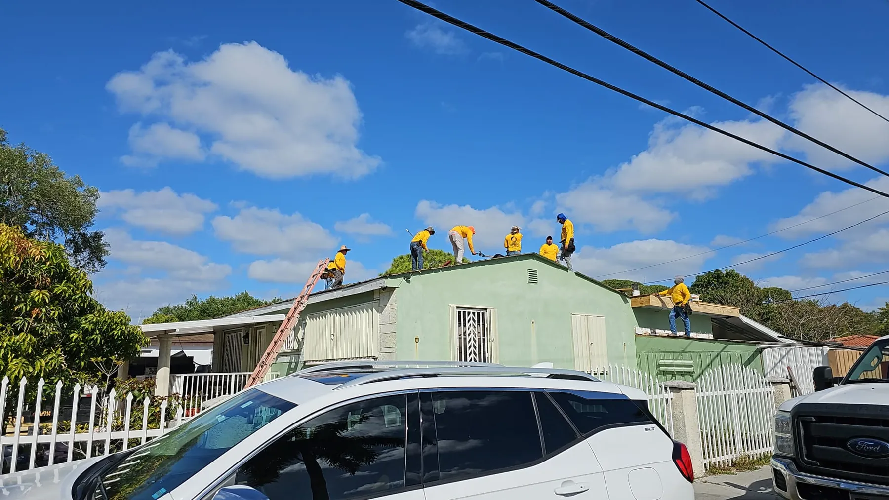 Cuadrilla de Global Contractors en un techo, vista desde la calle