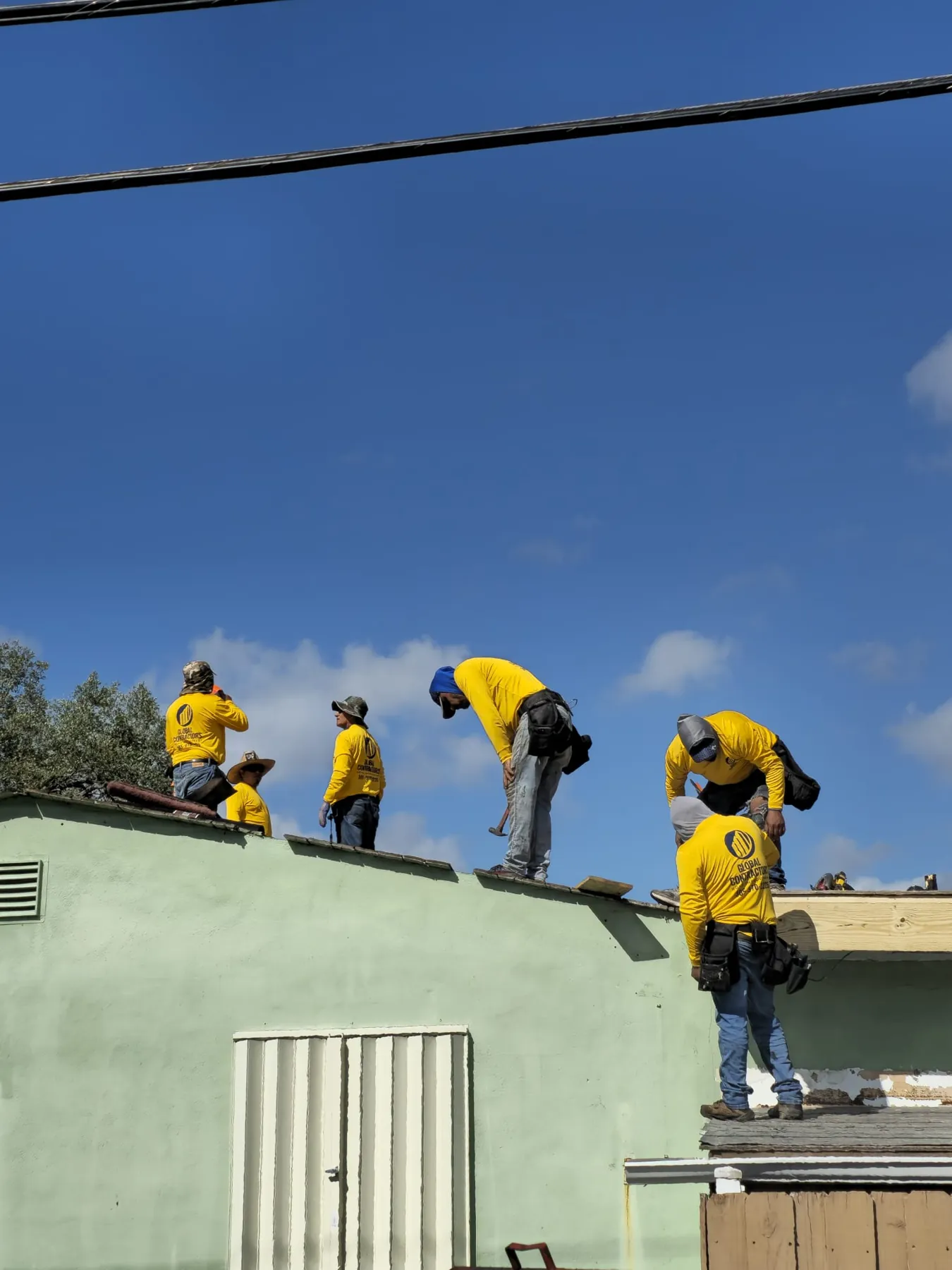 Cuadrilla de Global Contractors trabajando en un techo