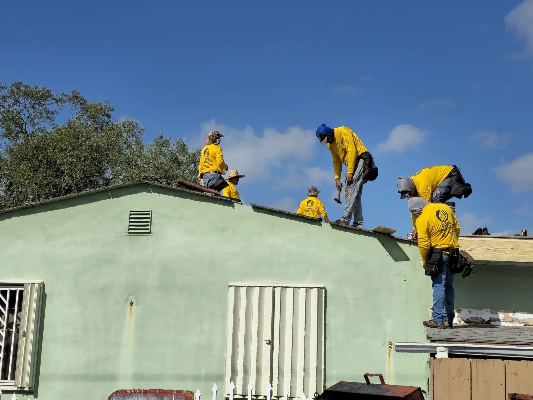 Cuadrilla de Global Contractors trabajando en un techo