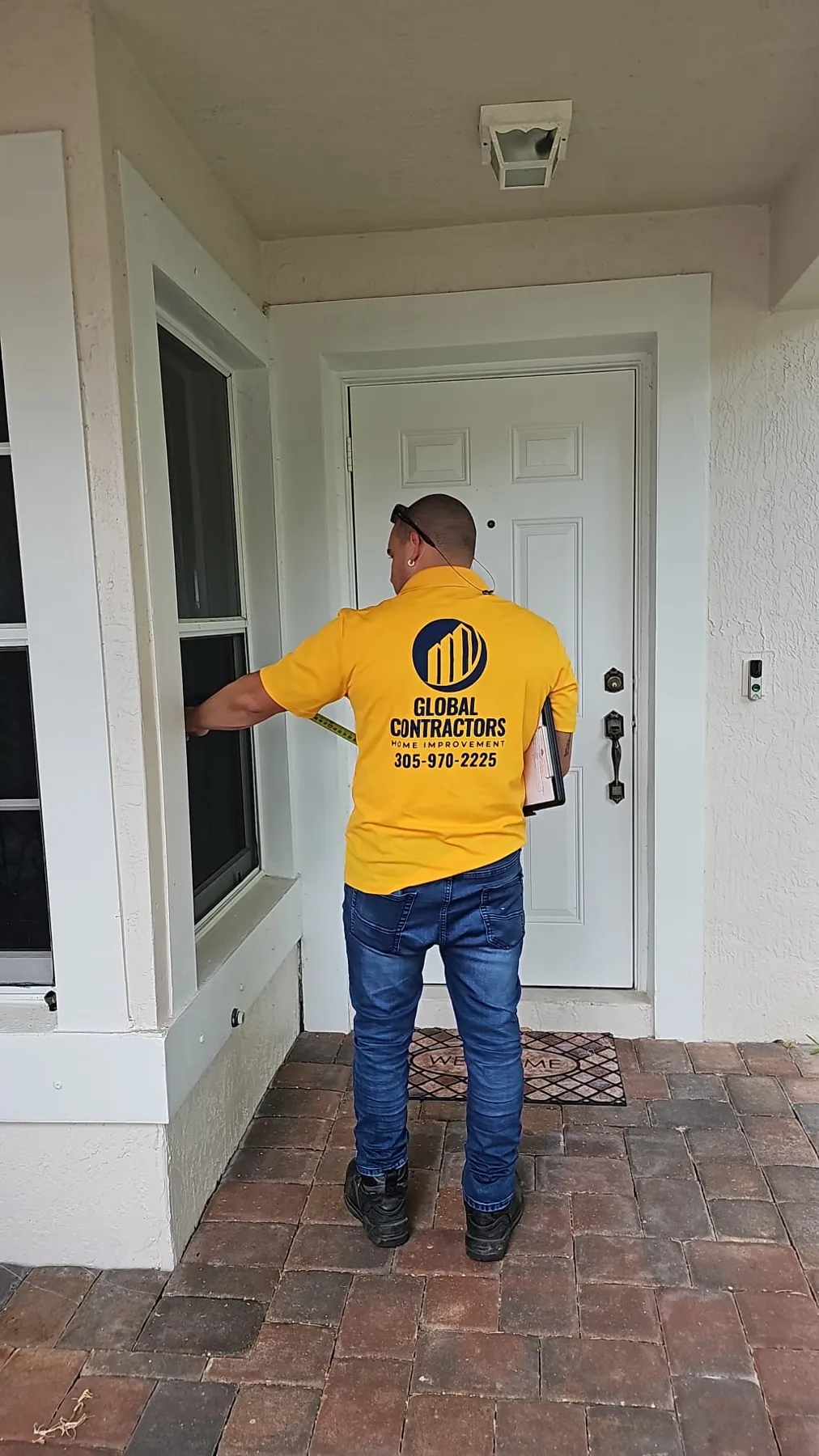 Instalador de Global Contractors midiendo una puerta de entrada