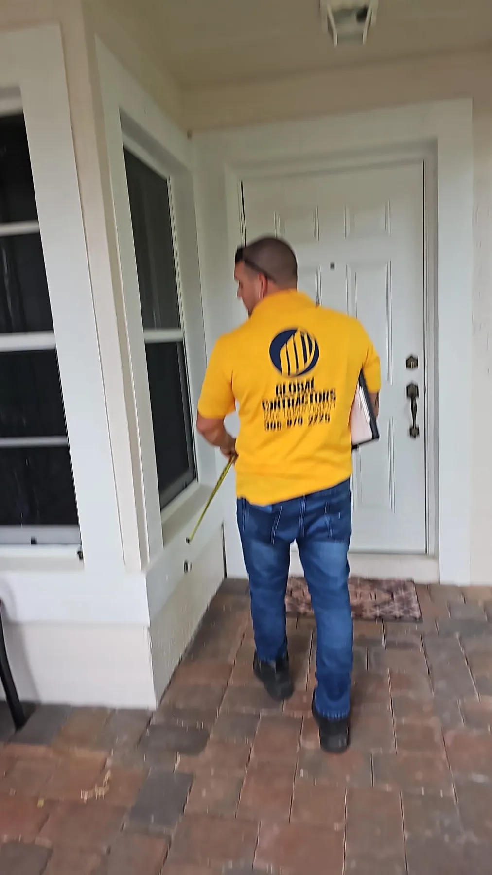 Instalador de Global Contractors midiendo una puerta de entrada