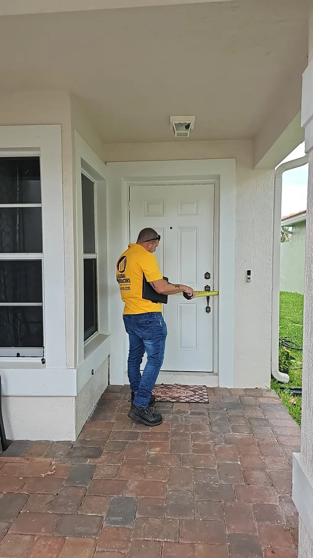 Instalador de Global Contractors midiendo una puerta de entrada