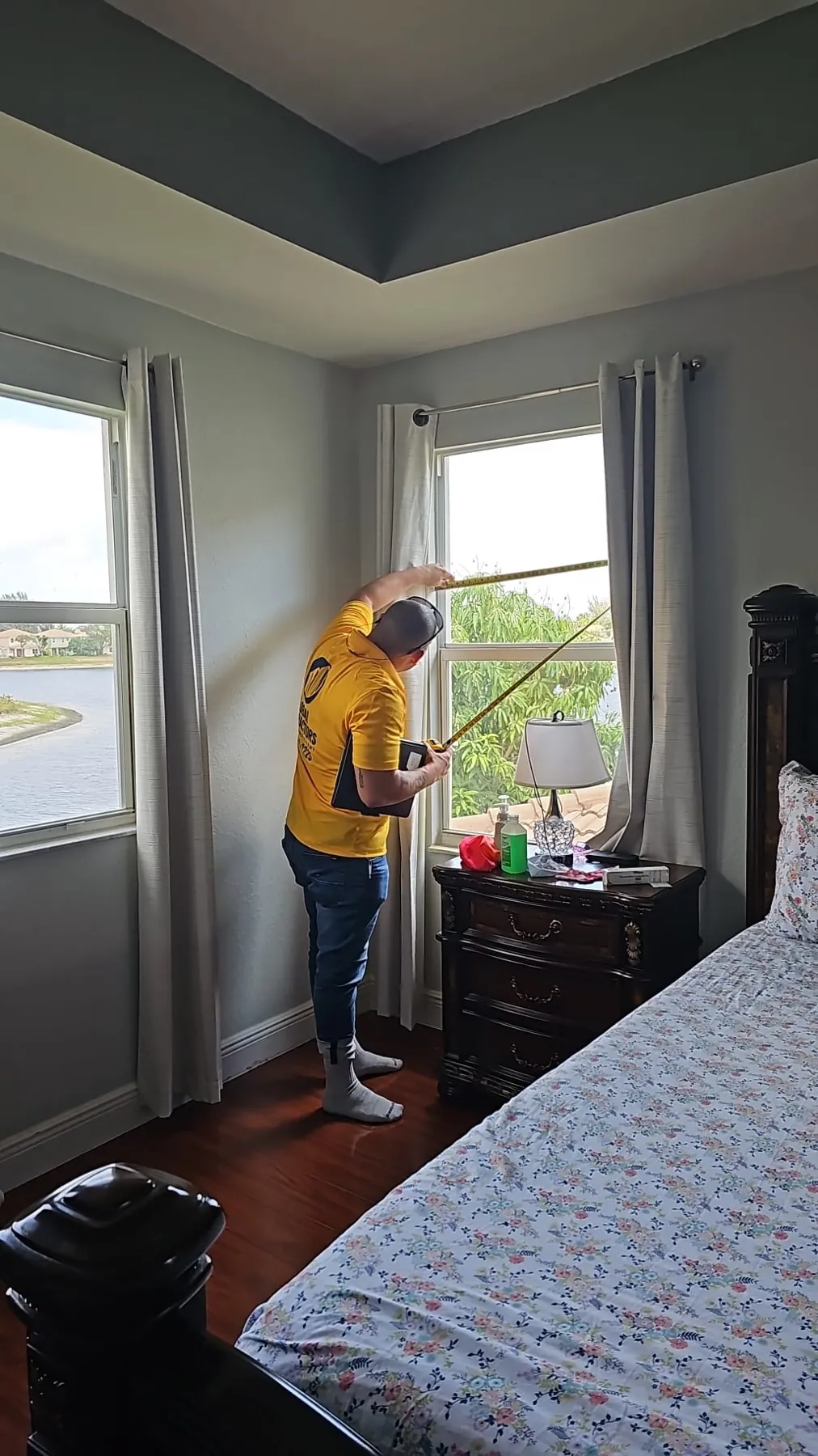 Instalador de Global Contractors midiendo la ventana de un dormitorio