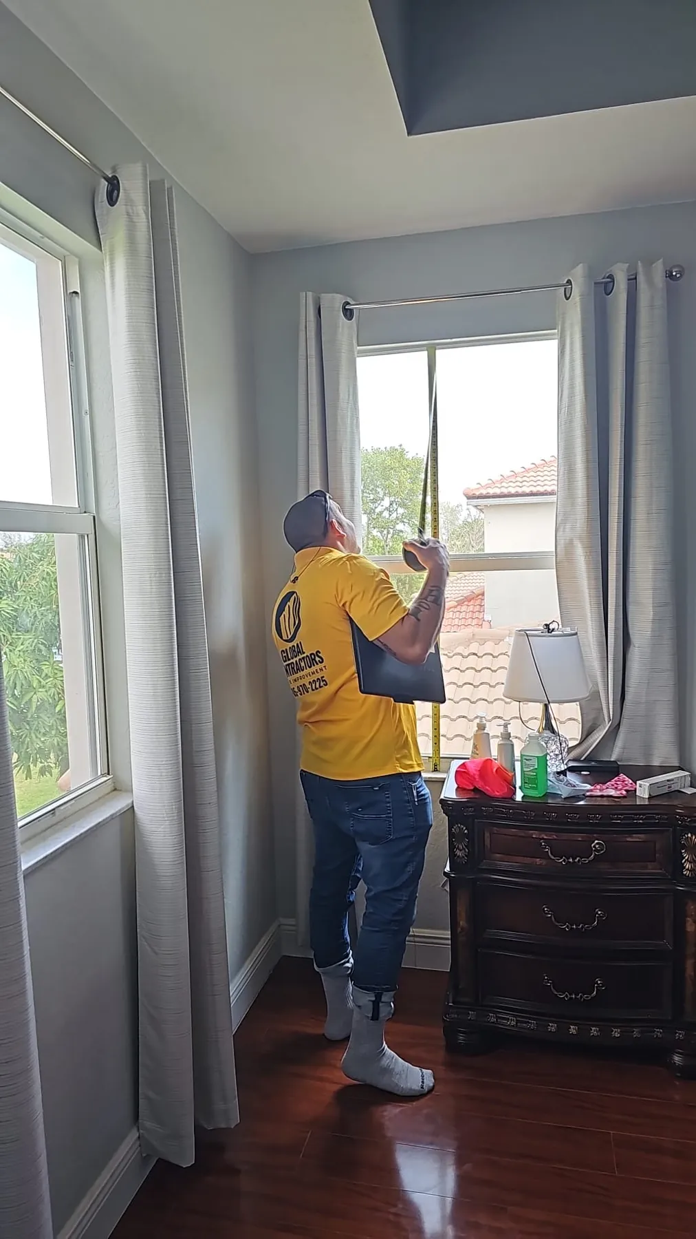 Instalador de Global Contractors midiendo la ventana de un dormitorio