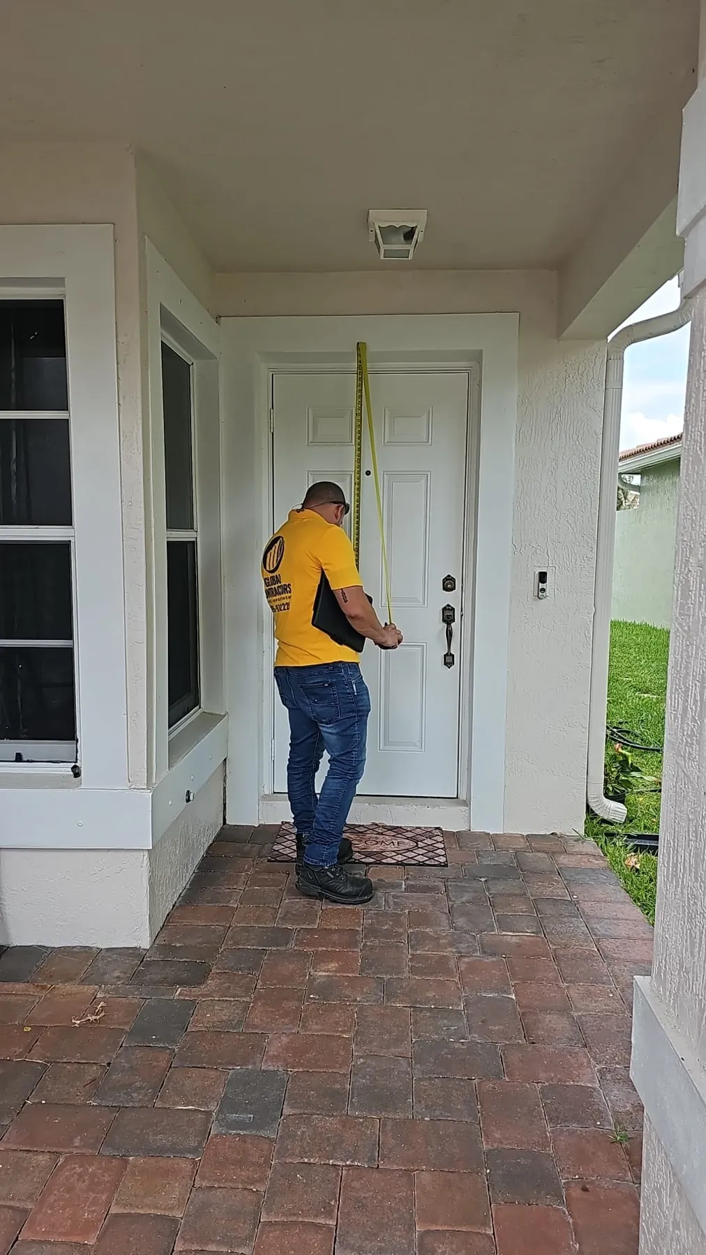 Instalador de Global Contractors midiendo una puerta de entrada