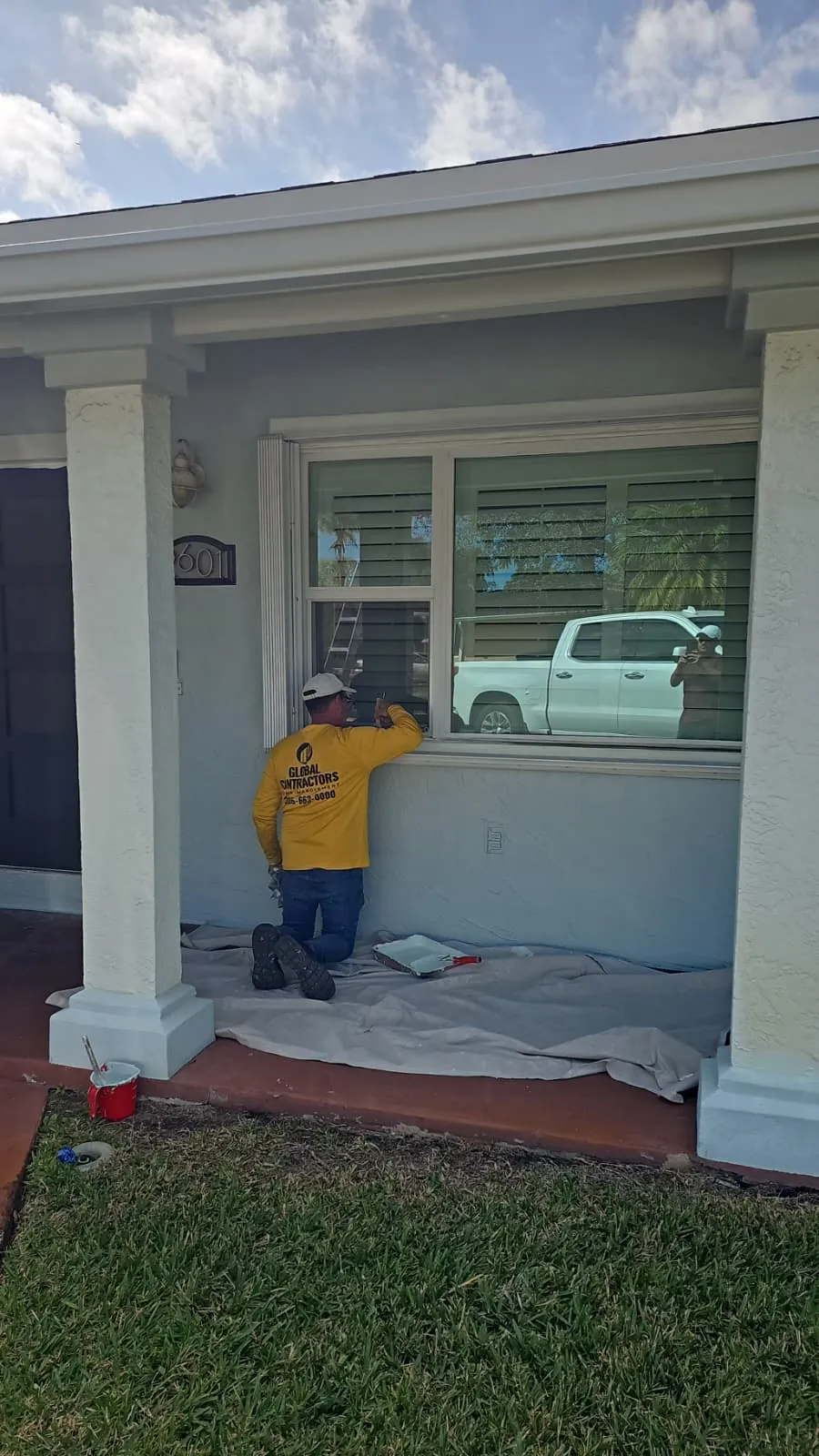 Instalador de Global Contractors junto a una ventana de impacto nueva